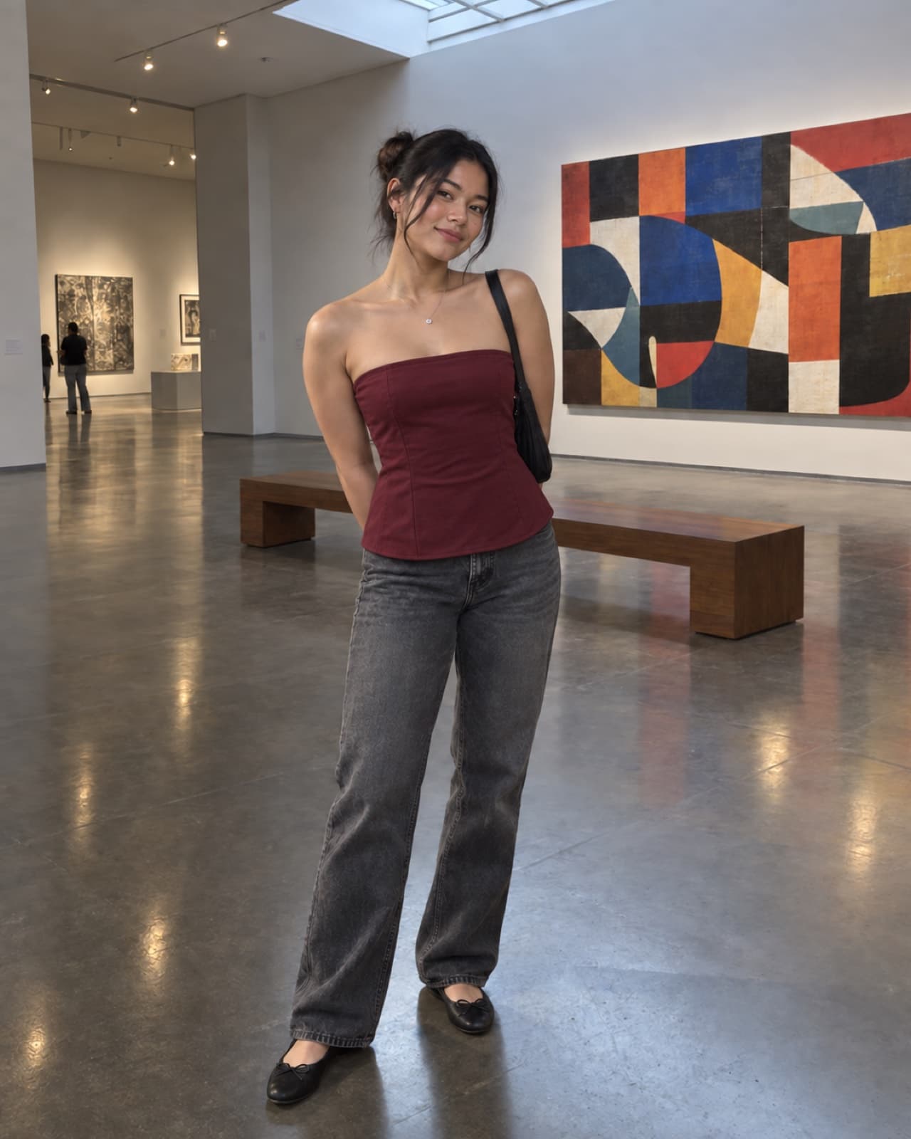 A woman wearing the burgundy tube top in an art museum